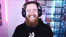 a man with a beard wearing headphones and a cat ear headband .