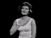 a black and white photo of a woman singing with her hands in the air