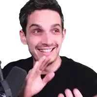 a man in a black shirt is smiling and waving his hands