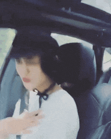 a woman is sitting in the back seat of a car with her eyes closed