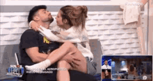 a man and a woman are sitting on a bed .