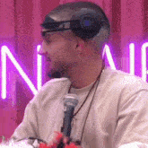 a man is wearing headphones and holding a microphone .