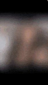 a blurred image of a person 's face in a dark room .
