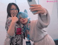 two women are posing for a selfie and one has a lanyard with a name tag that says @ruuna_070