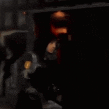 a blurry photo of a person standing in a dark room .