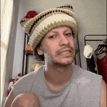 a man wearing a knitted hat and a gray shirt with the word good on it
