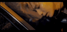a woman is laying in the back seat of a car with her head out the window .
