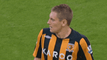 a man wearing a yellow and black striped shirt with karoo on it