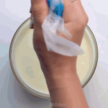 a person is holding a plastic bag over a bowl of liquid ..