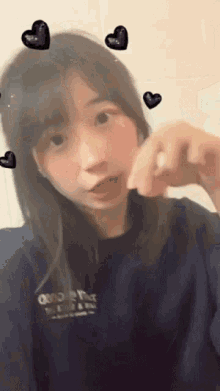 a girl taking a selfie with hearts around her head and a shirt that says o'neill on it