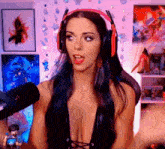 a woman wearing headphones and a very revealing top is speaking into a microphone