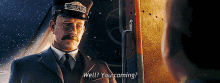 a man with a mustache wearing a conductor 's hat is talking to another man .