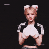 a girl wearing a cat ear headband is holding a pair of white gloves