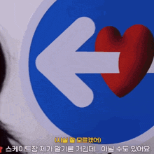 a blue sign with an arrow pointing to the left and a red heart on it