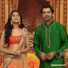a man in a green shirt and a woman in a red top are standing next to each other ..