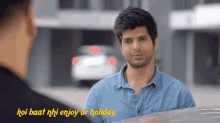 a man in a blue shirt is talking to another man with the words koi baat nhi enjoy ur holiday below him