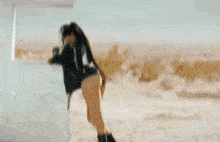 a woman in shorts is standing next to a white car in the desert .