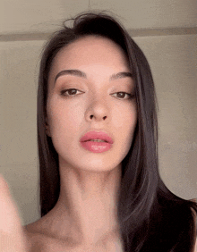 a woman with long dark hair looks at the camera