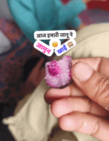 a person holding a piece of food with a sticker that says ' aaj '