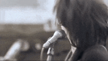 a woman is singing into a microphone while playing a piano .