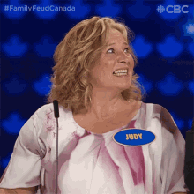 a woman wearing a name tag that says judy stands in front of a microphone