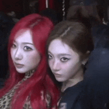 two girls with red hair are posing for a picture together .