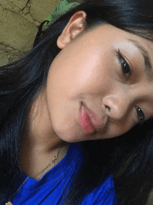 a close up of a woman 's face with a blue shirt