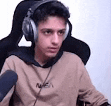 a young man wearing headphones is sitting in a chair .