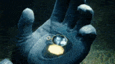 a person is holding a locket in their hand with a picture of a family inside of it .