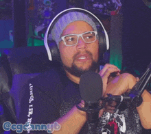a man wearing headphones and glasses says " okay "