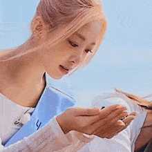 a close up of a woman holding a small object in her hand .