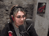 a woman wearing headphones and a barrels sweatshirt is sitting in front of a microphone