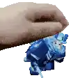 a hand is holding a blue toy on top of another toy .