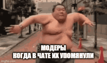 a shirtless sumo wrestler is walking down a street with his arms outstretched in a meme .