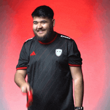 a man wearing a black shirt that says syner on the side