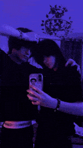 two people are taking a picture of themselves with their phones