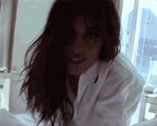 a woman with long hair is wearing a white lab coat