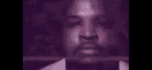 a close up of a man 's face with a pink light coming out of it .
