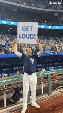 a baseball player holds a sign that says get loud