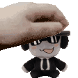 a hand is putting a stuffed animal on top of a stuffed animal wearing sunglasses and headphones .