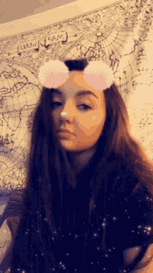 a girl wearing a snapchat filter is standing in front of a map that says cam on it