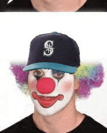 a man wearing a baseball cap with the letter s on it looks like a clown