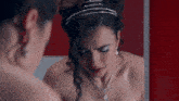 a woman in a wedding dress is looking at herself in a mirror