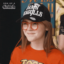 a young girl wearing a hat that says damn seagulls