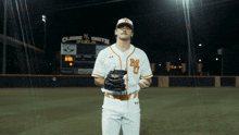 a baseball player stands in front of claude m smith field