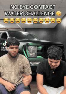 two men are sitting in front of a green car and laughing with the caption " no eye contact water challenge "