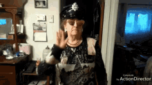 an elderly woman wearing a police hat and glasses is waving