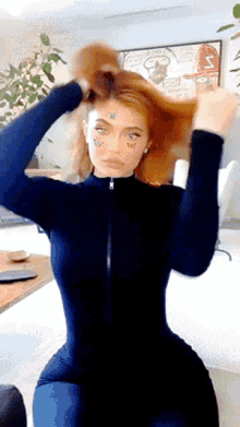 a woman in a black jumpsuit has a sticker on her face that says s on it