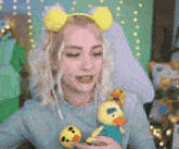 a woman wearing a headband and holding a stuffed duck .