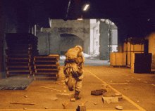 a soldier carrying a large bag runs through a warehouse